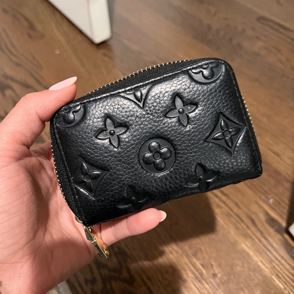Black imprint with gold hardware accordion style card wallet.